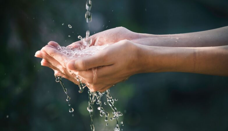 Eine Person hält ihre Hände unter Wasser