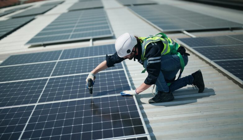 Arbeiter montiert Solarpanel mit Bohrmaschine | SMA Speicher Wechselrichter